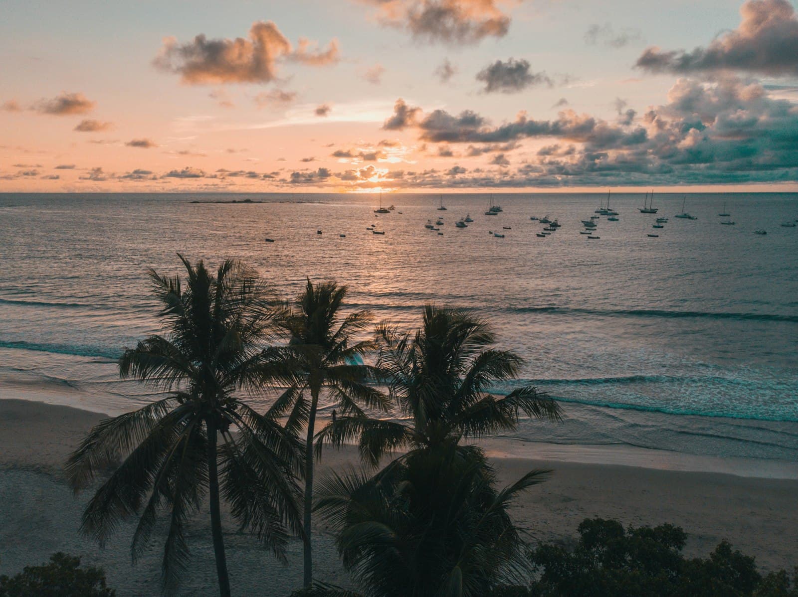 Boats moored off the beach at Tamarindo at sunset